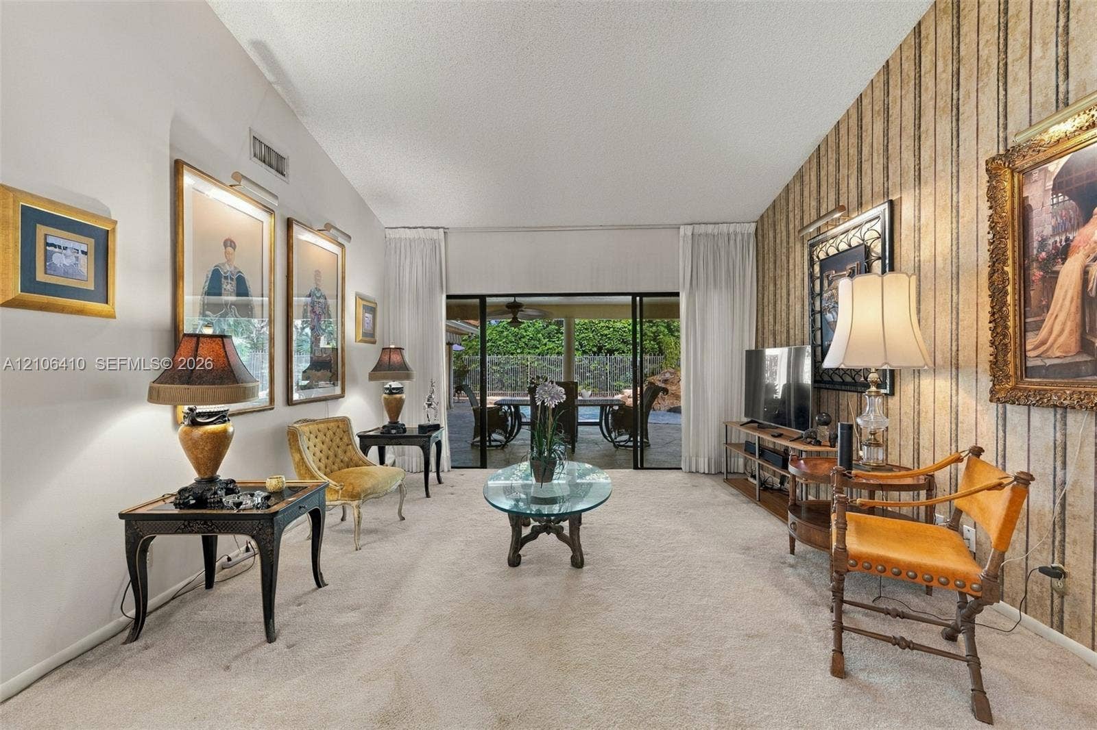 1725 Lakeshore Circle, Weston, FL 33326 Living space featuring vaulted ceilings, floor-to-ceiling sliding glass doors, and decorative wall covering