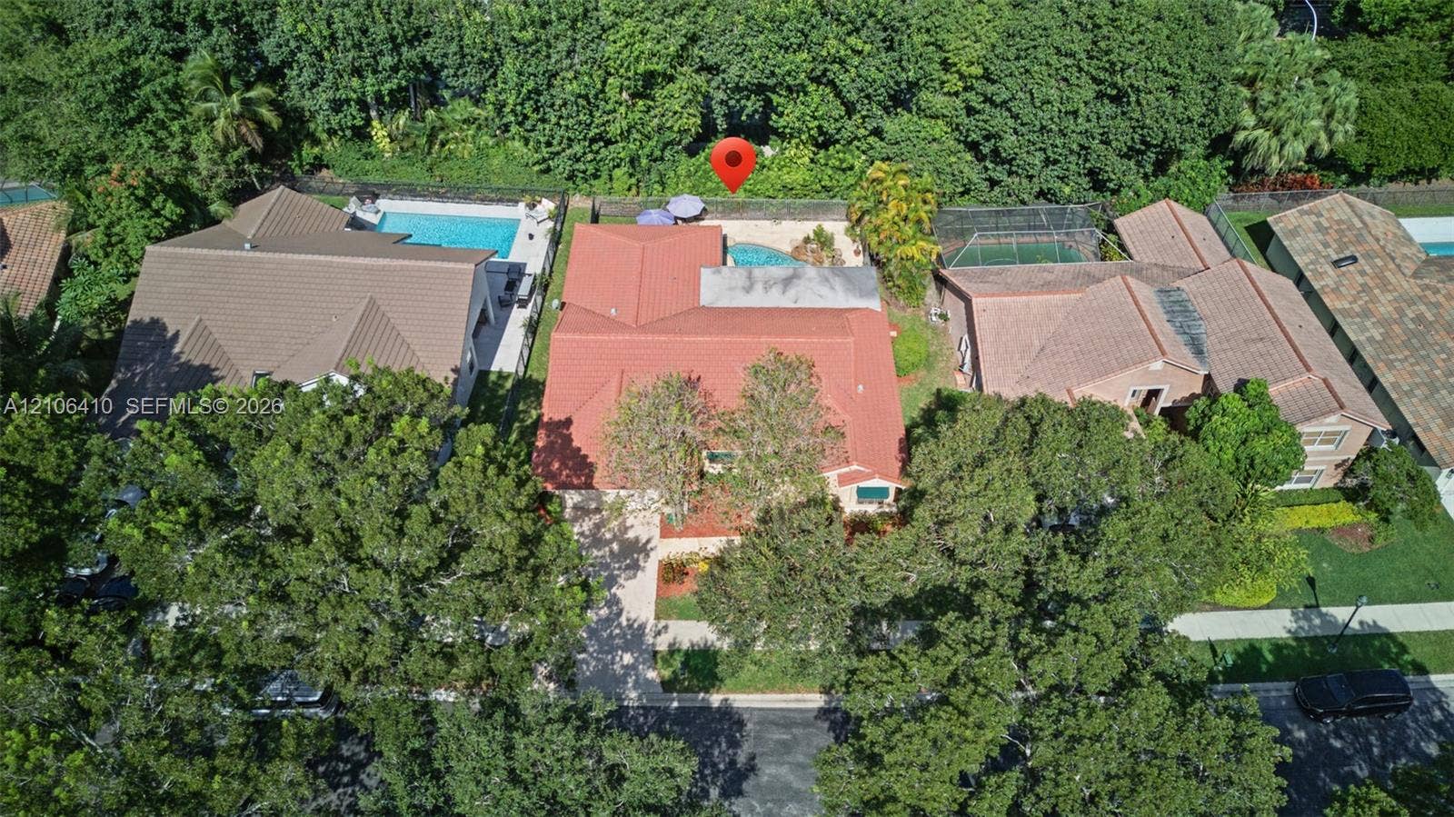 1725 Lakeshore Circle, Weston, FL 33326 Aerial perspective featuring a tile roof, an in-ground swimming pool, mature tree canopy, and dense perimeter landscaping