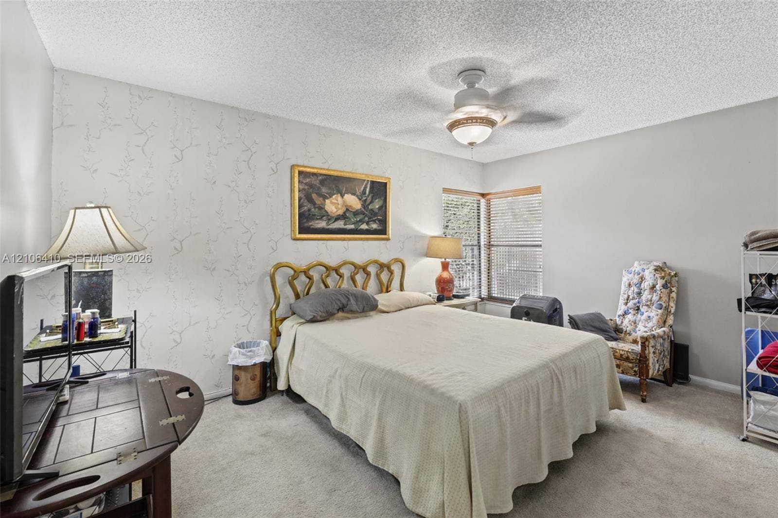 1725 Lakeshore Circle, Weston, FL 33326 Bedroom featuring neutral wall-to-wall carpeting, an accent wall with patterned wall covering, a multi-blade ceiling fan with integrated lighting, and horizontal window blinds