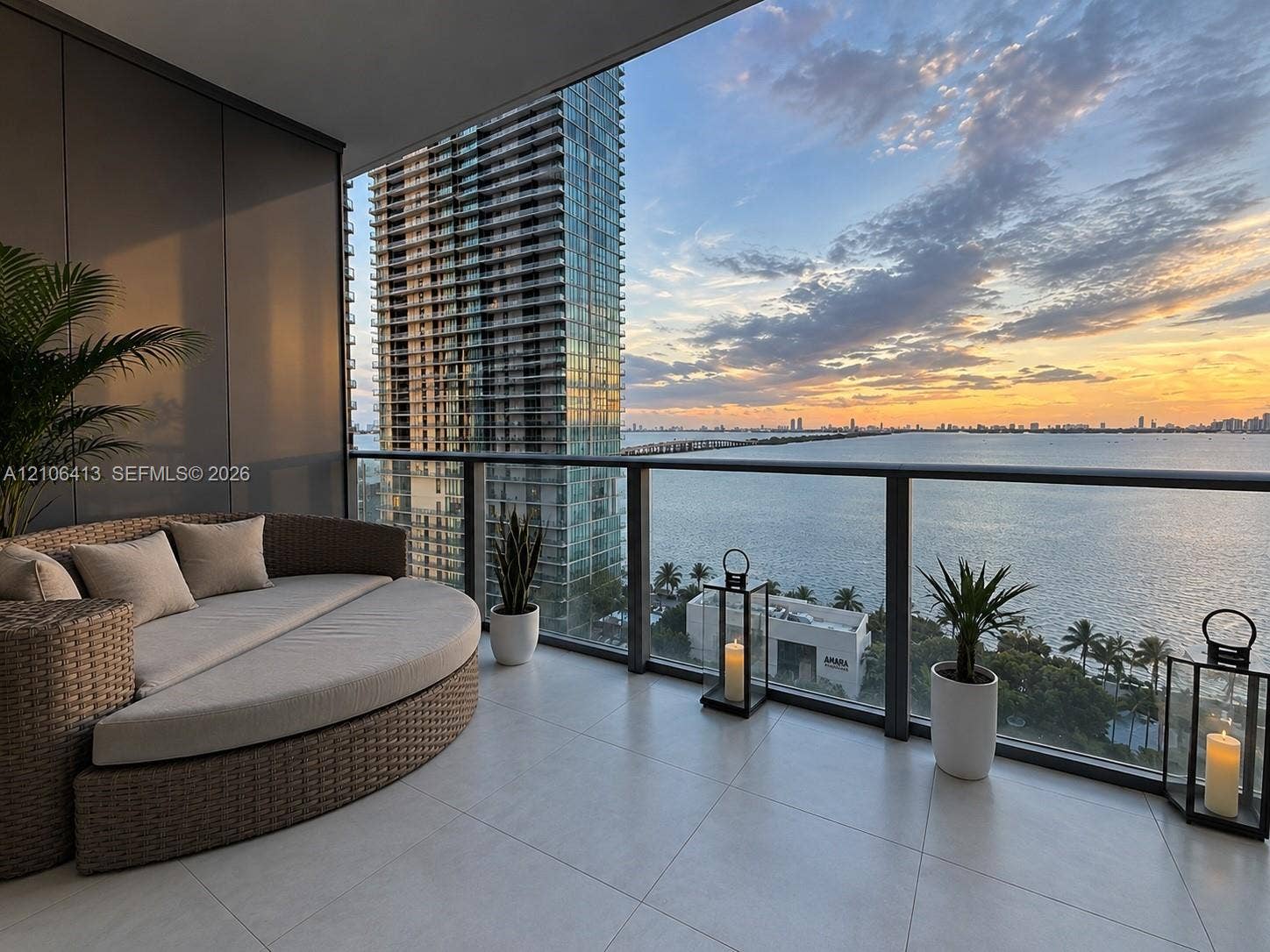 480 NE 31st Street, #1404, Miami, FL 33137 Private balcony featuring large-format tile flooring and a glass-paneled railing, overlooking open water and cityscape scenery
