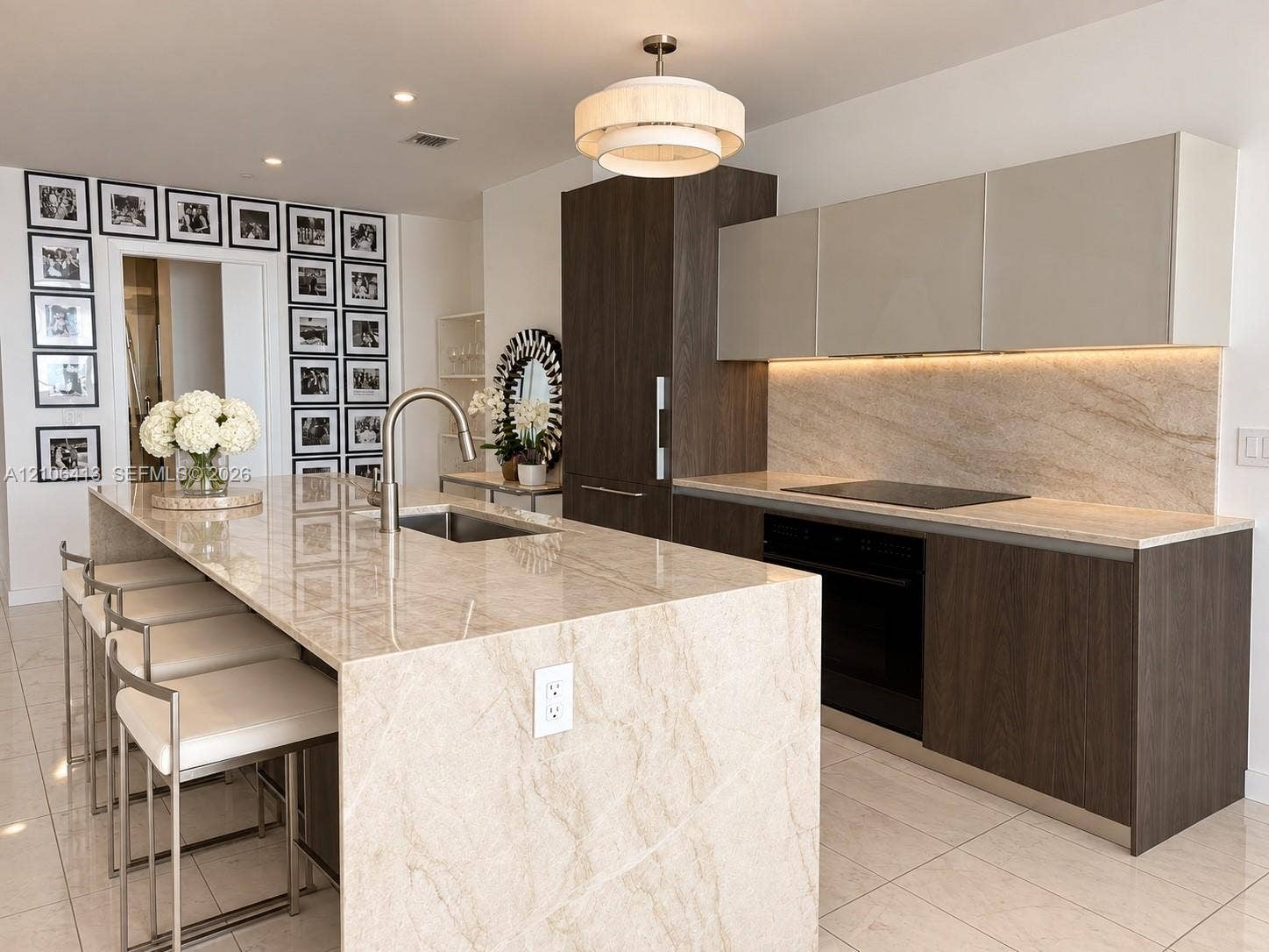 480 NE 31st Street, #1404, Miami, FL 33137 Kitchen featuring a stone-topped island with an integrated sink, custom two-tone cabinetry, recessed under-cabinet lighting, a built-in induction cooktop, and polished tile flooring