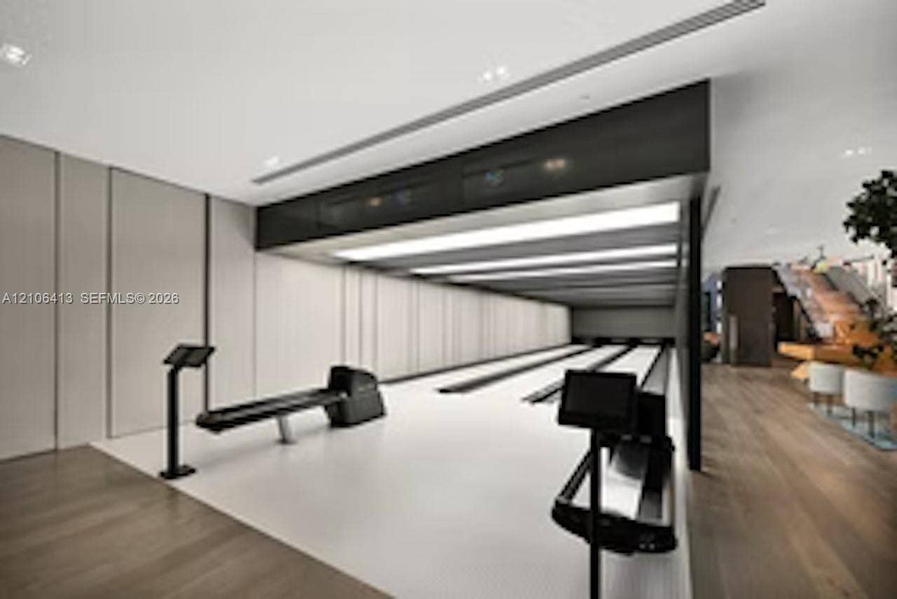 480 NE 31st Street, #1404, Miami, FL 33137 Multi-lane bowling alley featuring recessed ceiling lighting, wood-finish flooring, paneled wall detailing, and integrated console displays