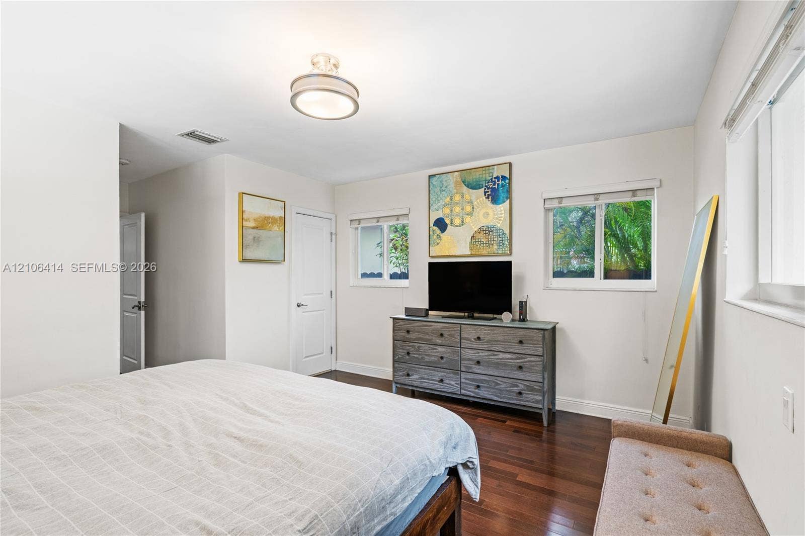9133 Garland Avenue, Surfside, FL 33154 Room with dark wood-finish flooring, two dual-pane windows with horizontal blinds, and a flush-mount circular ceiling light fixture