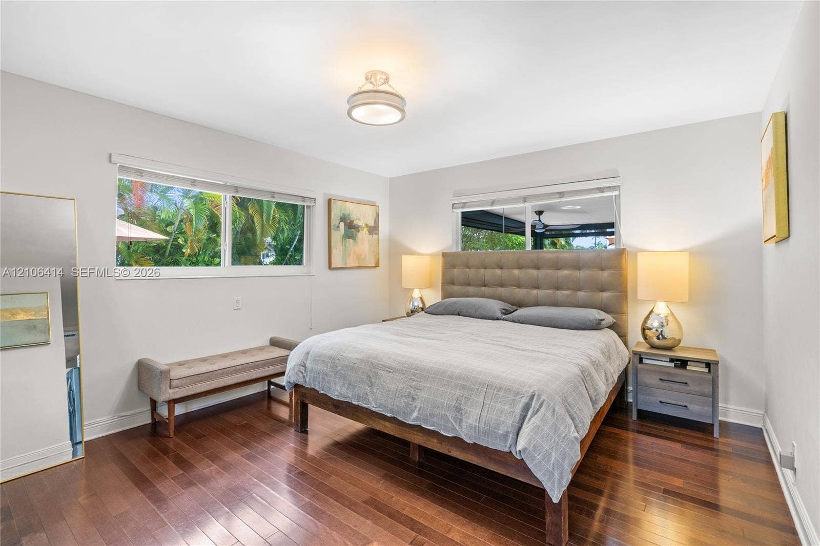 9133 Garland Avenue, Surfside, FL 33154 Wood-finish flooring, neutral wall tones, two large dual-pane windows, and a flush-mount overhead light fixture
