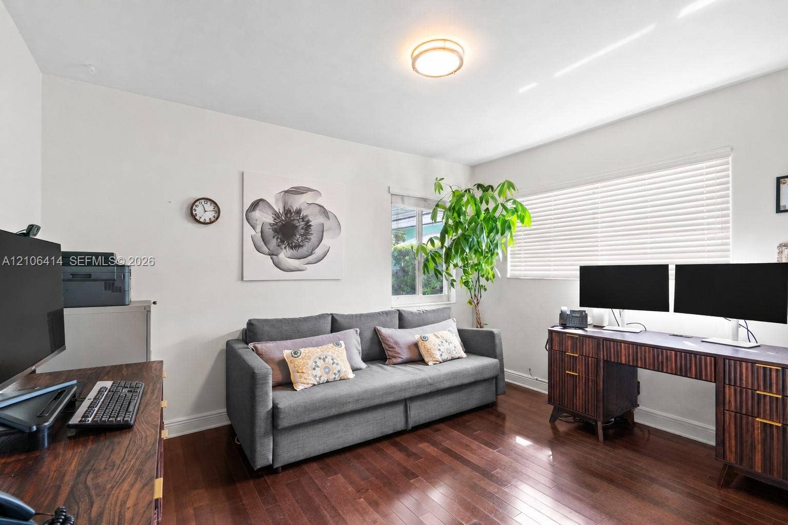 9133 Garland Avenue, Surfside, FL 33154 Room featuring wood-finish flooring, dual windows with horizontal blinds, and a central ceiling-mounted light fixture