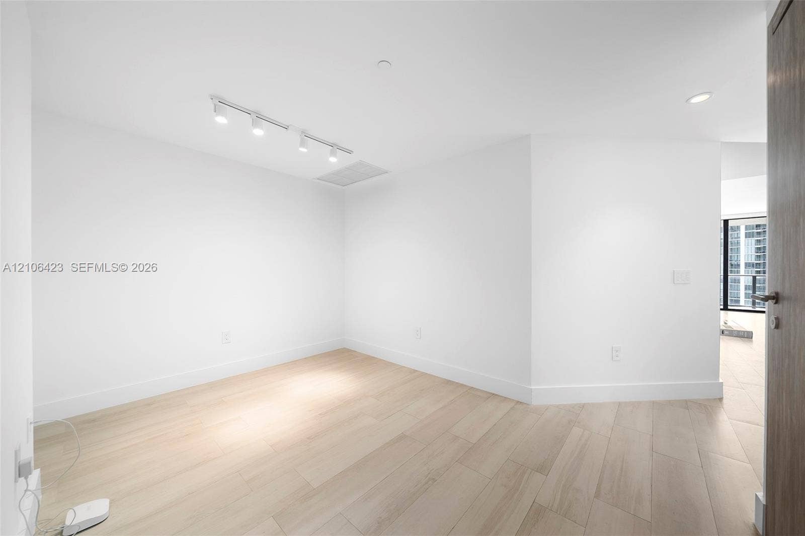 Interior space featuring light wood-finish flooring, recessed lighting, and adjustable track lighting