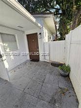 5712 Hollywood Boulevard, #3, Hollywood, Hollywood, FL 33021 Paved exterior patio with solid-surface privacy fencing, exterior wall-mounted lighting, and a neutral-toned door