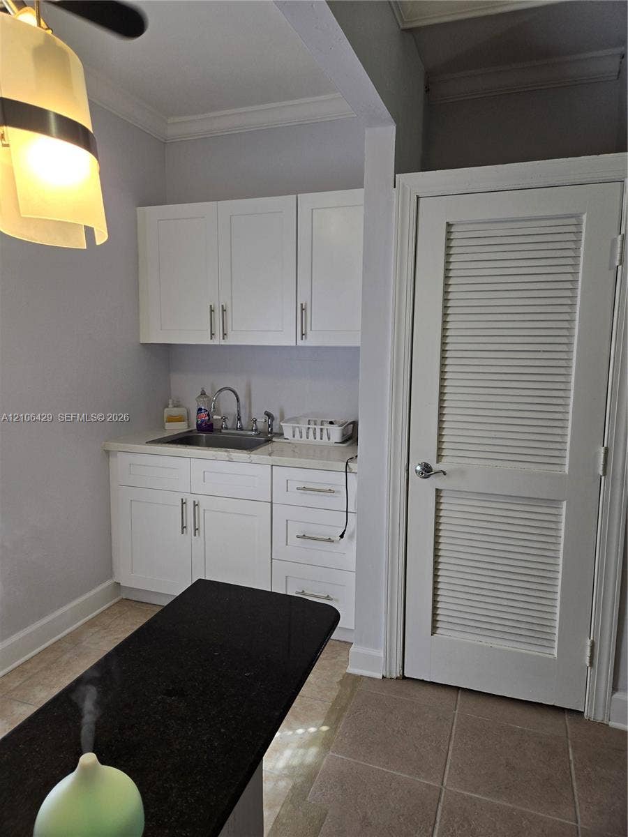 5712 Hollywood Boulevard, #3, Hollywood, Hollywood, FL 33021 White shaker-style cabinetry with metallic pulls, stone-surface countertops, undermount stainless steel sink, and louvered door