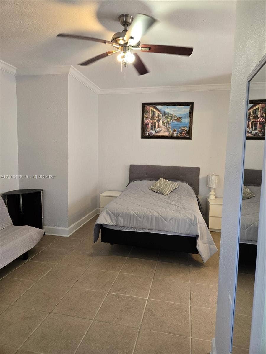 5712 Hollywood Boulevard, #3, Hollywood, Hollywood, FL 33021 Room featuring neutral wall paint, tile flooring, crown molding, and a central ceiling fan with integrated light fixture