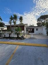 5712 Hollywood Boulevard, #3, Hollywood, Hollywood, FL 33021 Exterior facade featuring white stucco walls, brick accents, decorative masonry screen blocks, and a paved courtyard with a tiered stone fountain