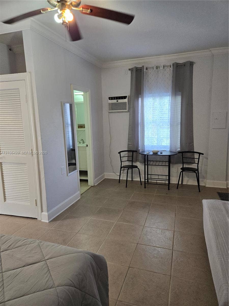 5712 Hollywood Boulevard, #3, Hollywood, Hollywood, FL 33021 Room featuring large-format ceramic tile flooring, a louvered-door closet, crown molding, and a ceiling fan with integrated lighting