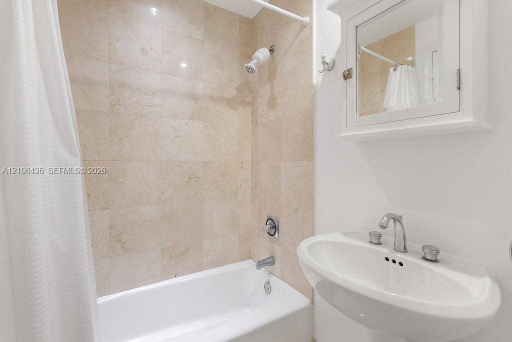 808 Brickell Key Drive, #2102, Miami, Miami, FL 33131 Full-height stone tile shower surround, pedestal sink with polished chrome fixtures, and white wall-mounted medicine cabinet