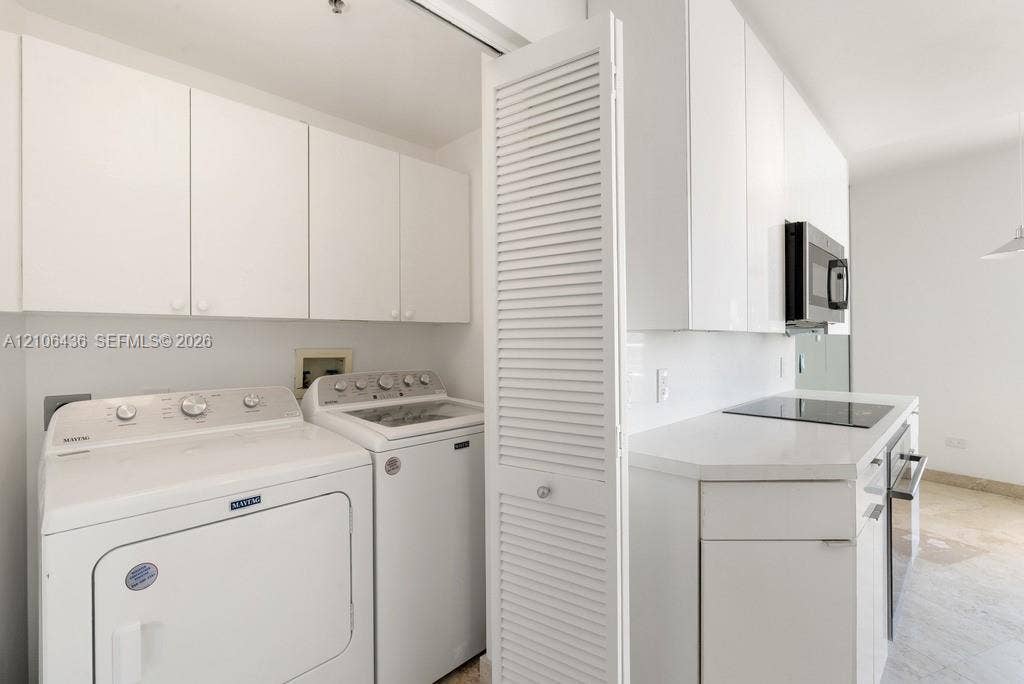 808 Brickell Key Drive, #2102, Miami, Miami, FL 33131 Laundry area featuring white cabinetry, louvered closet doors, and hard-surface countertops