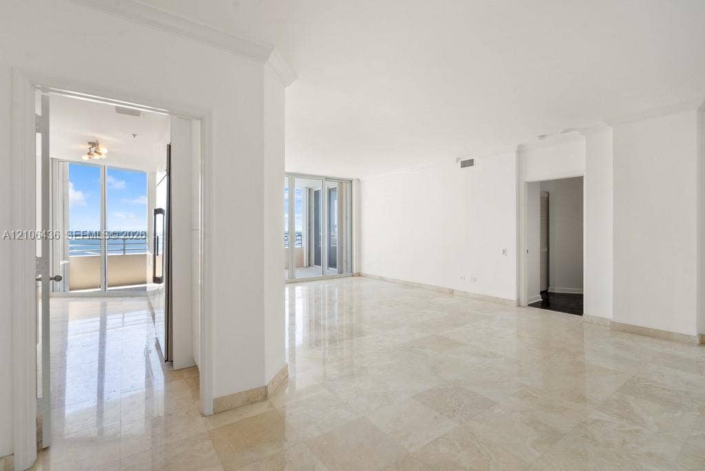 808 Brickell Key Drive, #2102, Miami, Miami, FL 33131 Open interior featuring polished stone flooring, crown molding, floor-to-ceiling glass sliding doors, and private balcony access