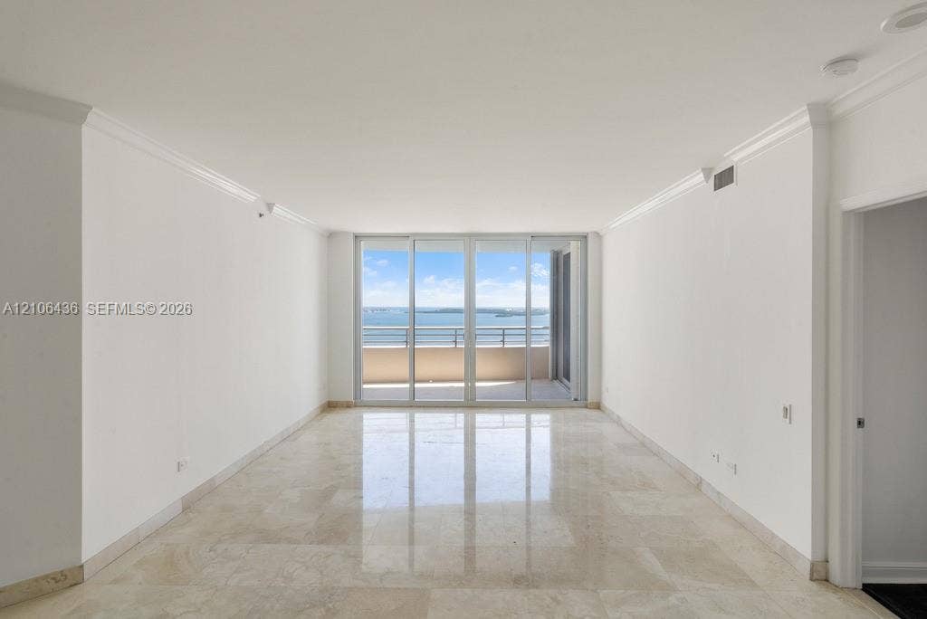 808 Brickell Key Drive, #2102, Miami, Miami, FL 33131 Living area featuring polished stone flooring, crown molding, and floor-to-ceiling glass sliding doors opening to a private balcony