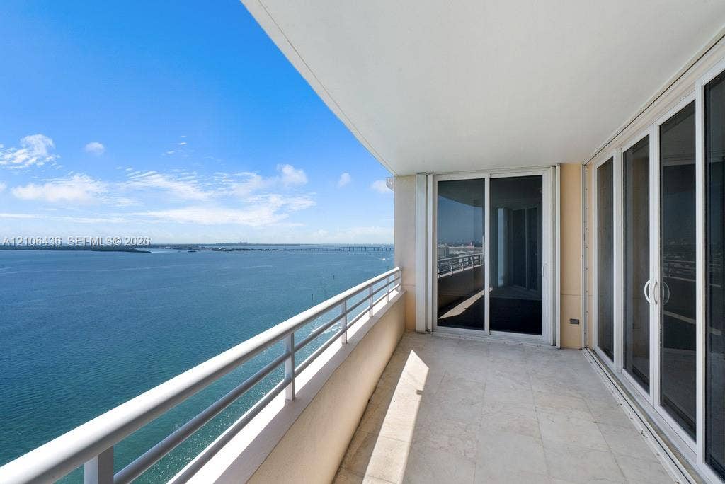 808 Brickell Key Drive, #2102, Miami, Miami, FL 33131 Covered balcony featuring stone tile flooring, a horizontal metal railing, and sliding glass door entry