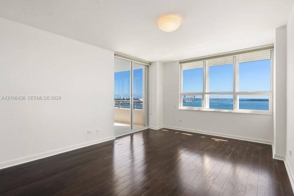 808 Brickell Key Drive, #2102, Miami, Miami, FL 33131 Dark wood-finish flooring, floor-to-ceiling windows, sliding glass door, recessed ceiling lighting, and covered balcony