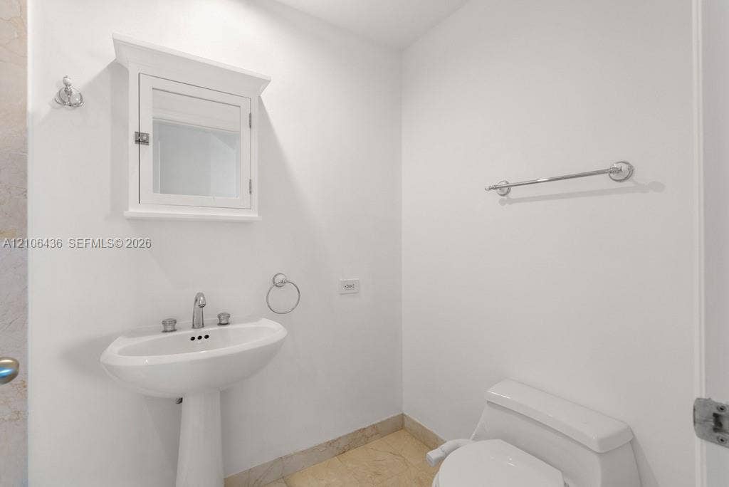 808 Brickell Key Drive, #2102, Miami, Miami, FL 33131 Pedestal sink with polished chrome fixtures, wall-mounted medicine cabinet with crown molding, and stone-finish flooring