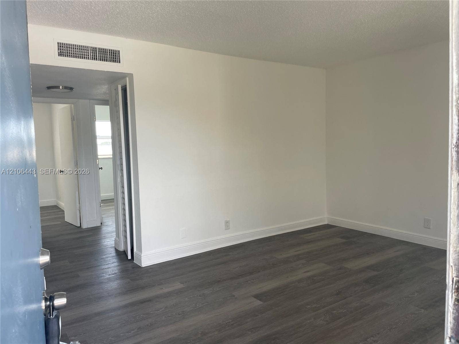 Interior space featuring wood-finish flooring, white walls, and interior passage doors