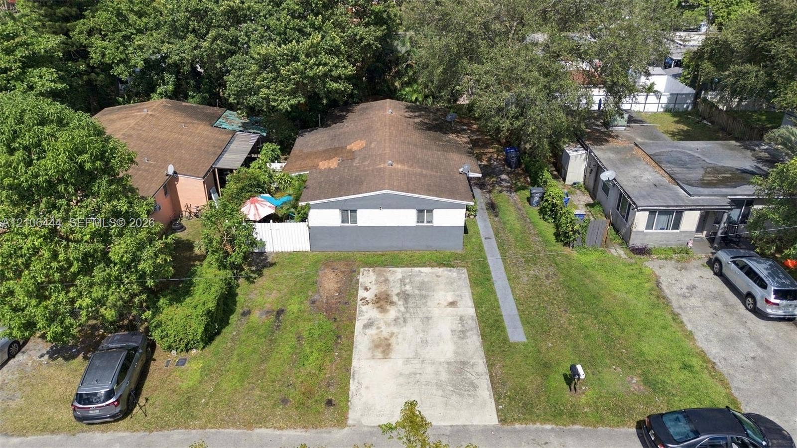 Single-story structure with a two-tone exterior, asphalt shingle roofing, and a dedicated concrete parking pad