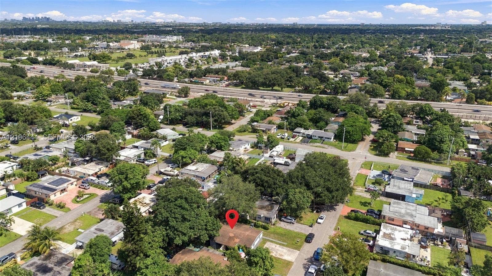 6351 Hayes Street, Hollywood, FL 33024 Single-story residence featuring a shingled roof, exterior masonry siding, and mature tree canopy situated on a rectangular lot