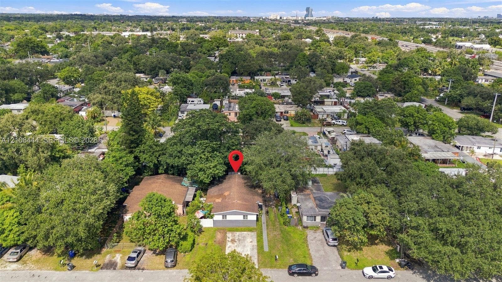 Aerial perspective of property featuring mature trees and a paved driveway
