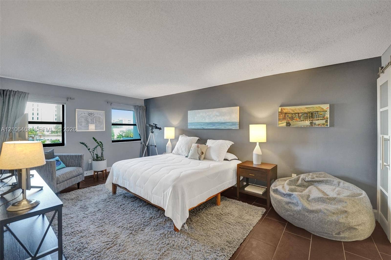 1201 S Ocean Drive, #218N, Hollywood, FL 33019 Bedroom featuring large dual windows, matte grey wall finish, and a sliding frosted glass paneled door