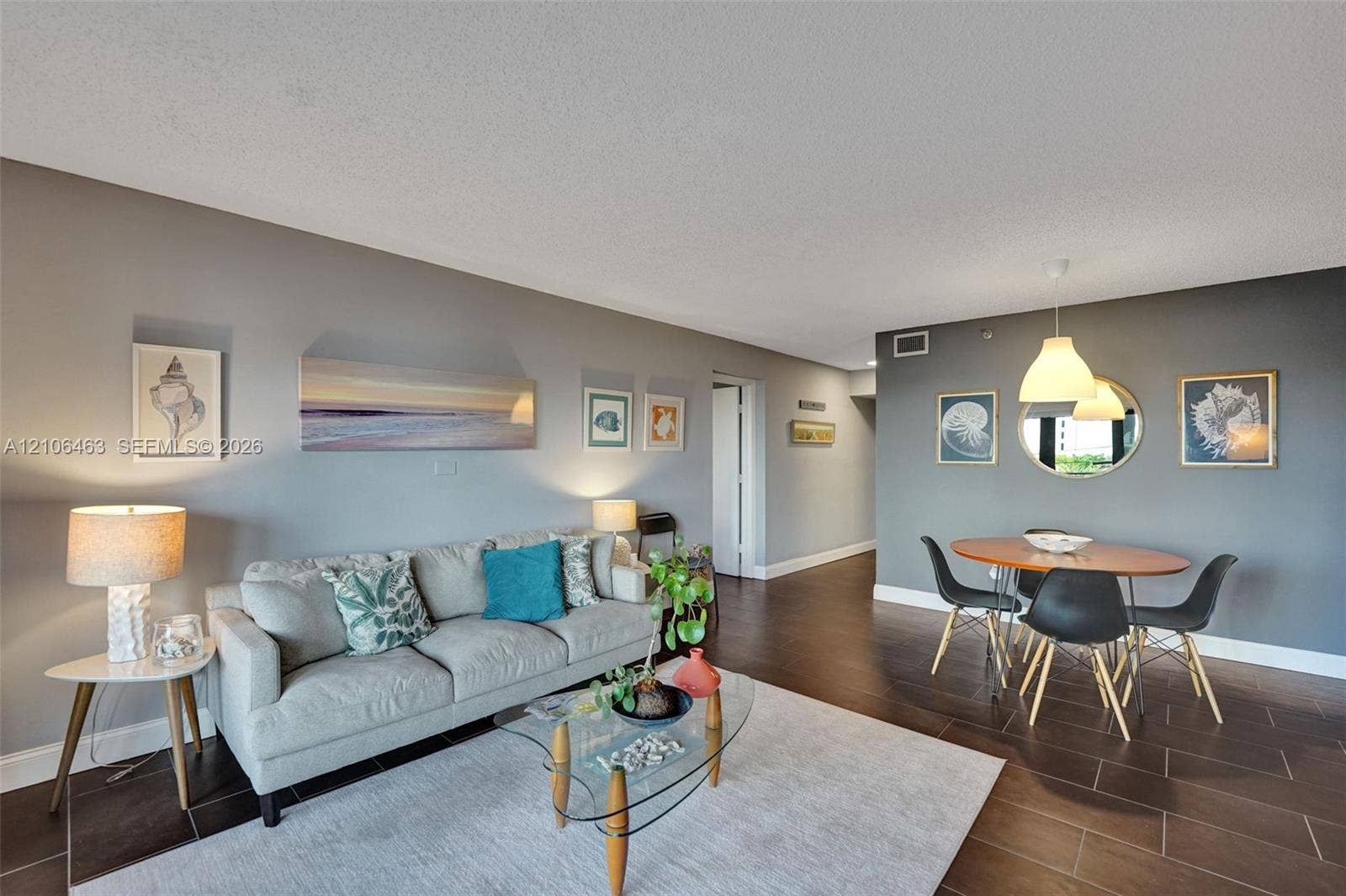 1201 S Ocean Drive, #218N, Hollywood, FL 33019 Open-concept main living area featuring dark tile flooring, dual-tone wall finishes, and suspended dome pendant lighting