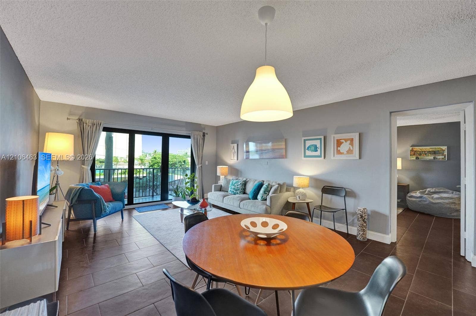 1201 S Ocean Drive, #218N, Hollywood, FL 33019 Living area featuring large format tile flooring, sliding glass doors, and a suspended pendant light fixture