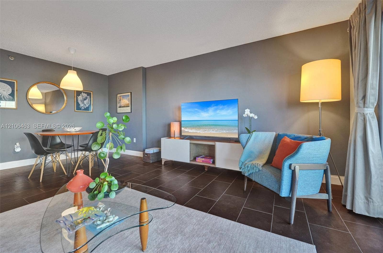 1201 S Ocean Drive, #218N, Hollywood, FL 33019 Open-concept living space featuring large-format tile flooring and a suspended cone-style pendant light