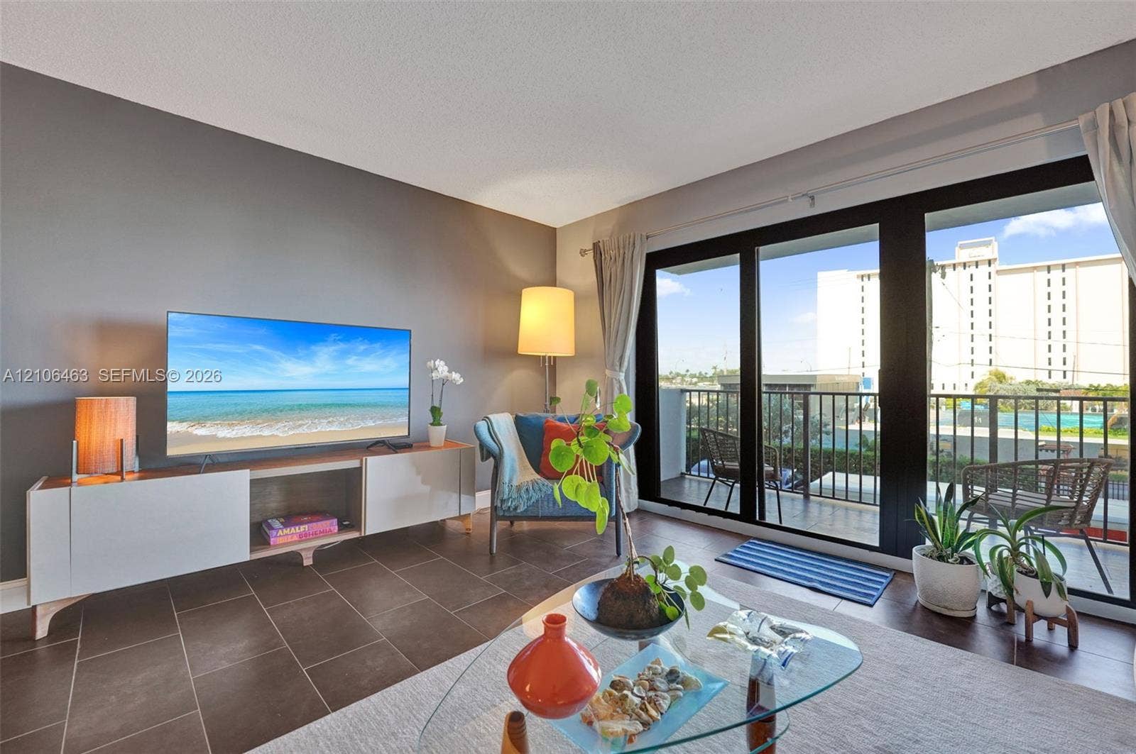 1201 S Ocean Drive, #218N, Hollywood, FL 33019 Large-format tile flooring, dark-toned accent wall, and expansive sliding glass doors opening to a private balcony