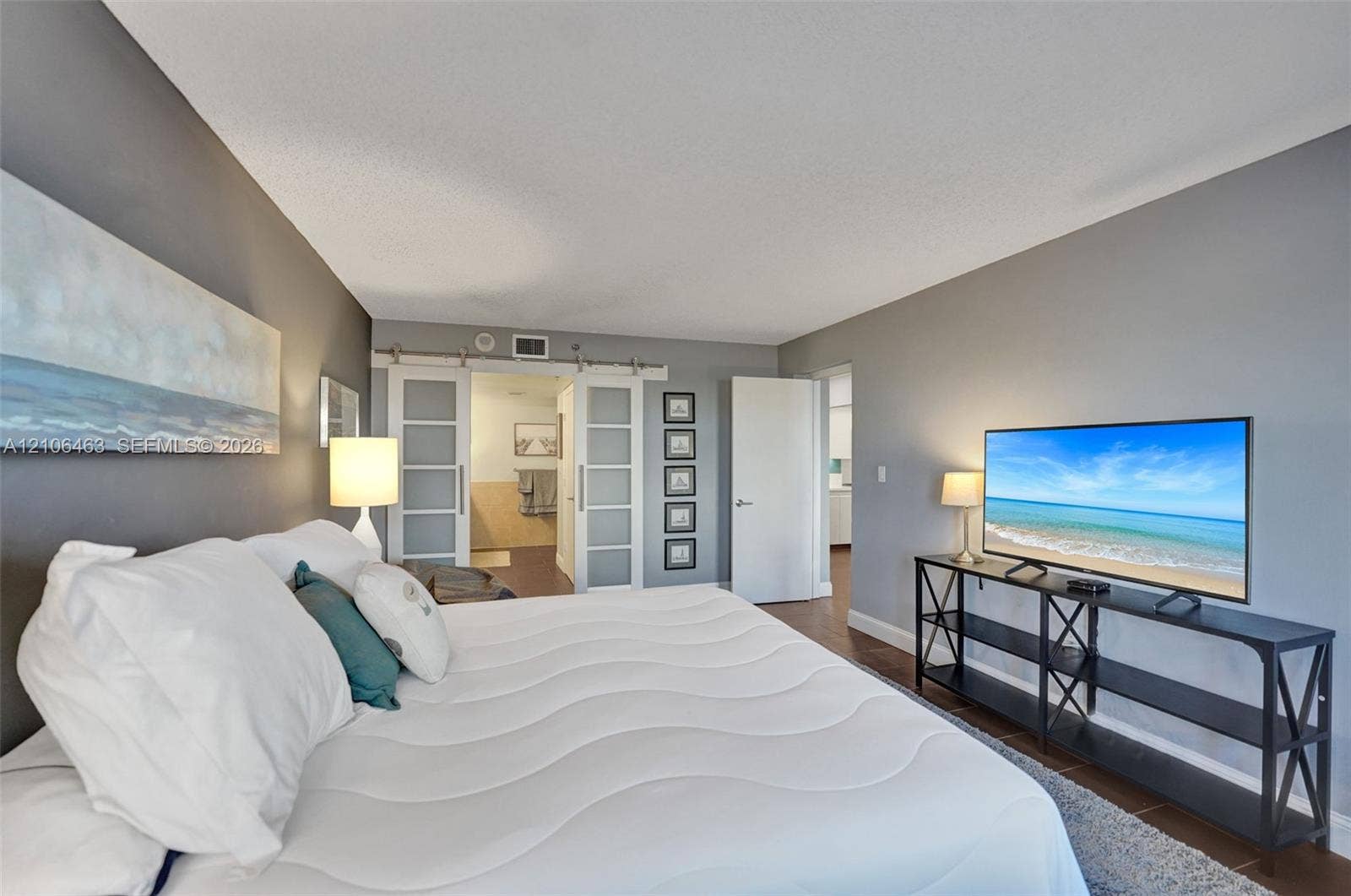 1201 S Ocean Drive, #218N, Hollywood, FL 33019 Dual sliding barn doors featuring frosted glass panels and metal hardware, complemented by wood-finish flooring