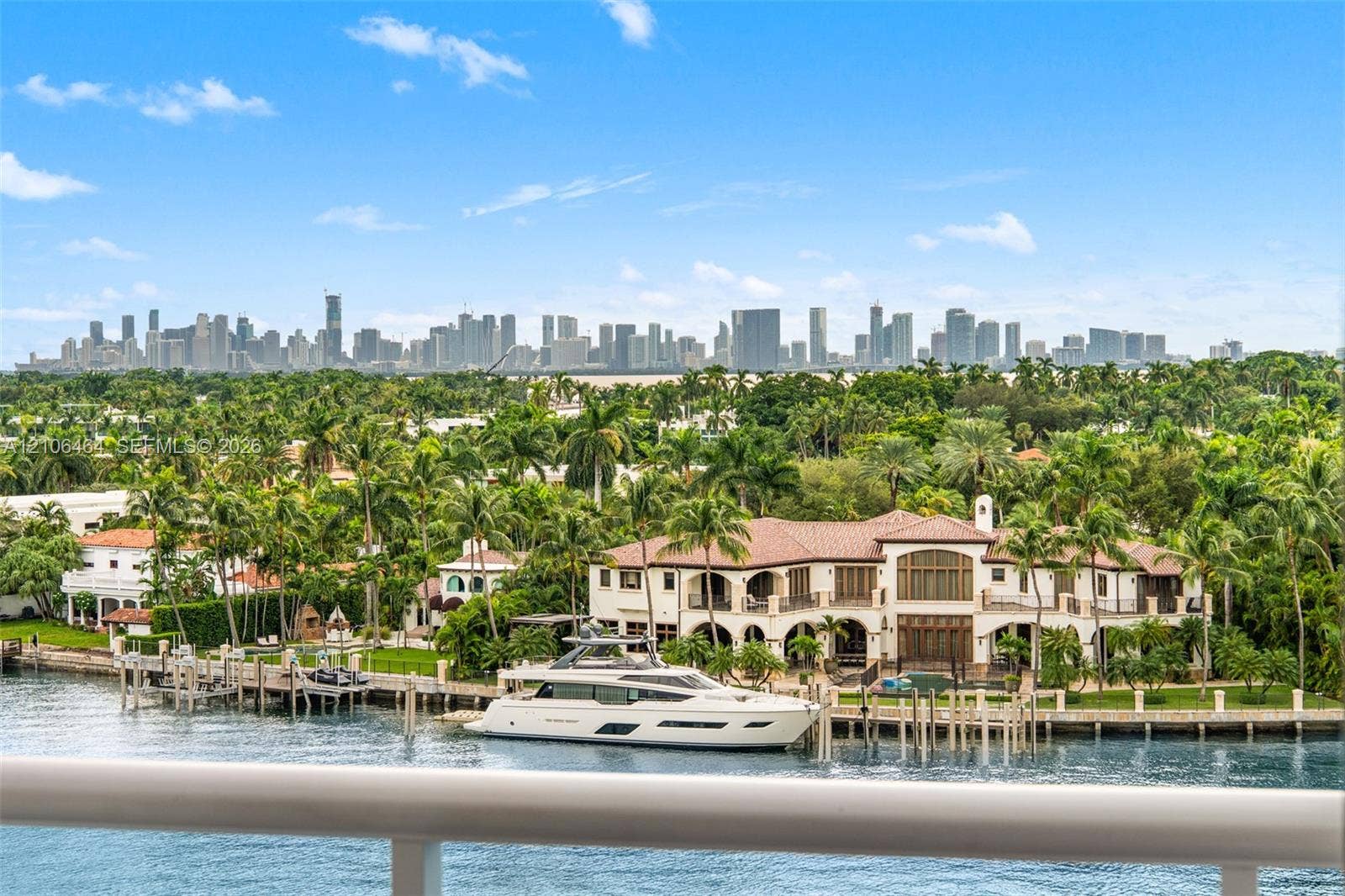 6770 Indian Creek Drive, #8E, Miami Beach, FL 33141 Waterfront estate featuring a private deep-water dock, multi-level arched loggias, terracotta tile roofing, and expansive skyline scenery