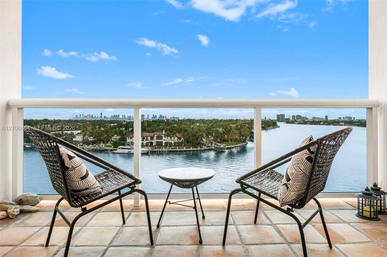 6770 Indian Creek Drive, #8E, Miami Beach, FL 33141 Covered balcony featuring tile flooring and a white railing overlooking a waterway and city skyline
