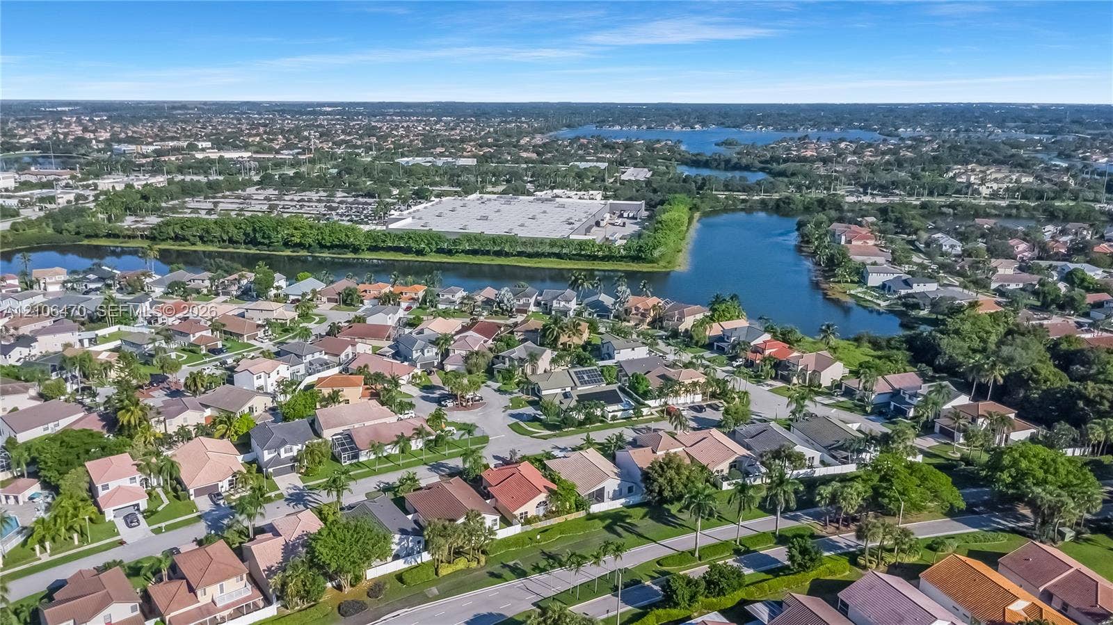 Aerial perspective featuring expansive residential lots, established palm landscaping, and proximity to inland waterway features