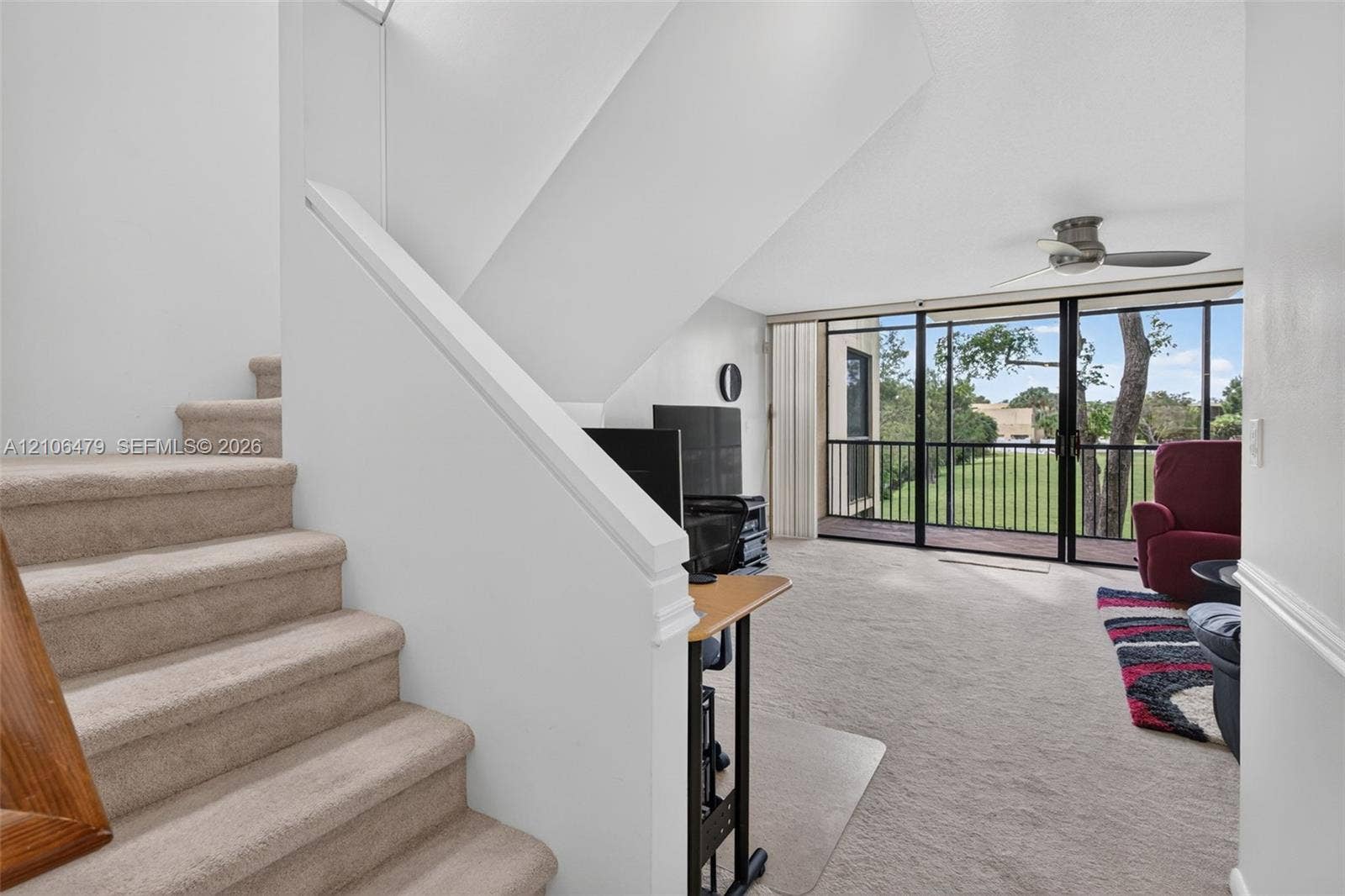 2800 SW 87th Avenue, #1113, Davie, FL 33328 Carpeted staircase featuring a painted wood railing, wall-to-wall carpeting, ceiling fan, and sliding glass doors with balcony access