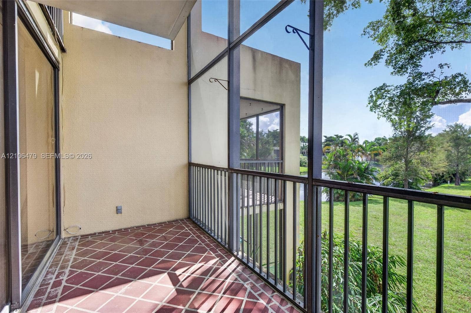 2800 SW 87th Avenue, #1113, Davie, FL 33328 Screened balcony featuring tiled flooring, metal railings, and a solid wall exterior