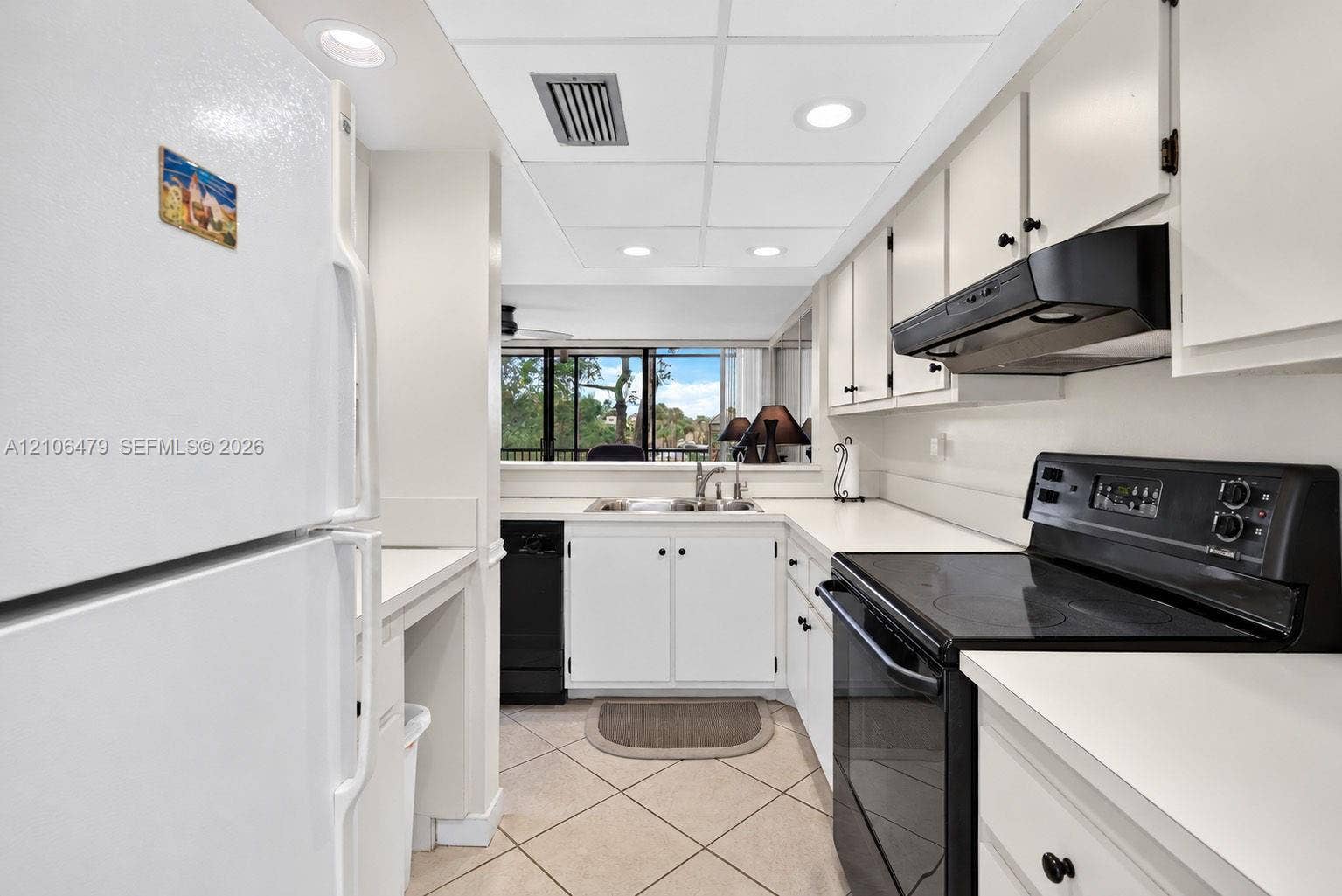 2800 SW 87th Avenue, #1113, Davie, FL 33328 Kitchen featuring white cabinetry, contrasting black appliances, recessed lighting, and tile flooring