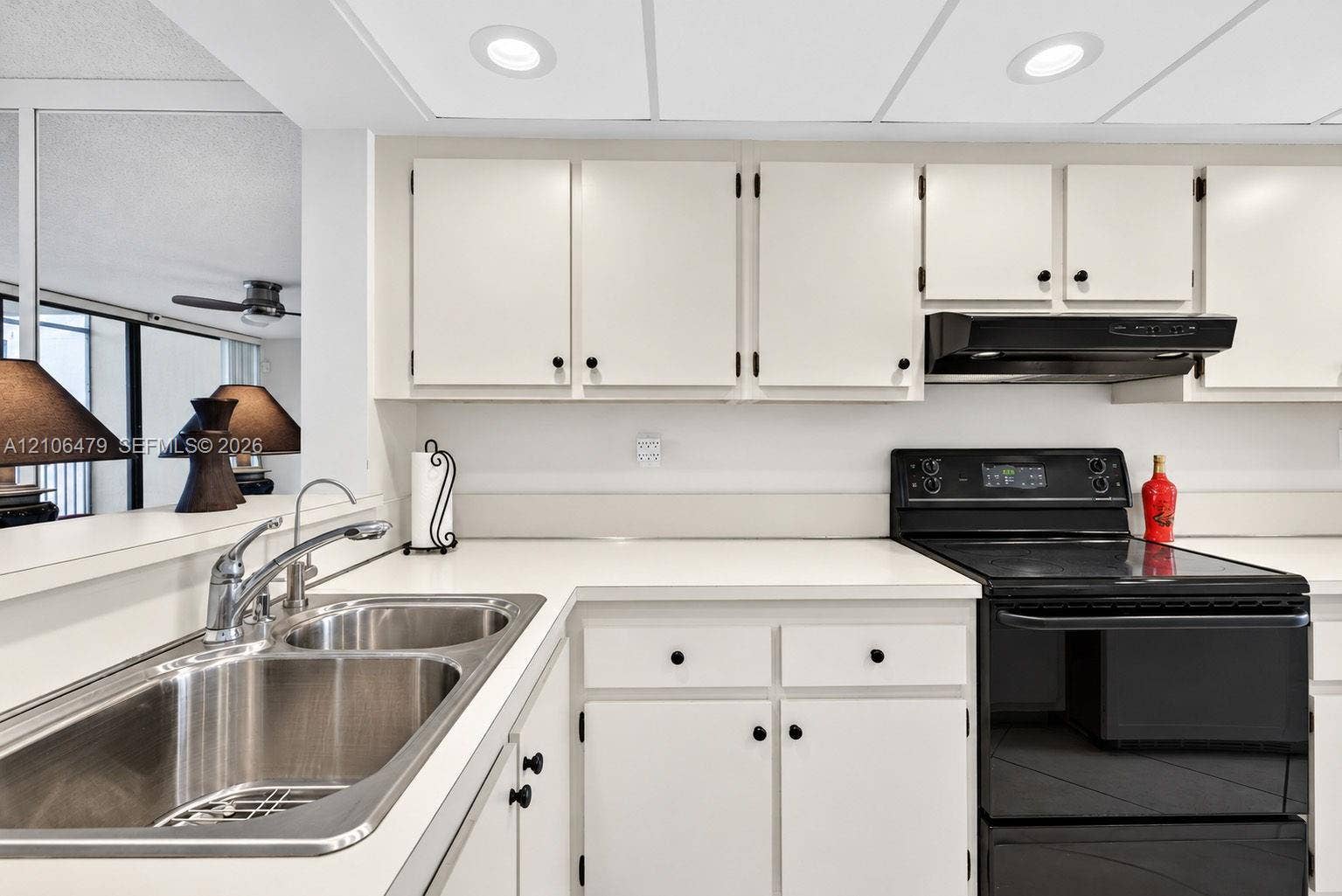 2800 SW 87th Avenue, #1113, Davie, FL 33328 Kitchen featuring white cabinetry, solid-surface countertops, dual-basin stainless steel sink, black range, and recessed ceiling lighting
