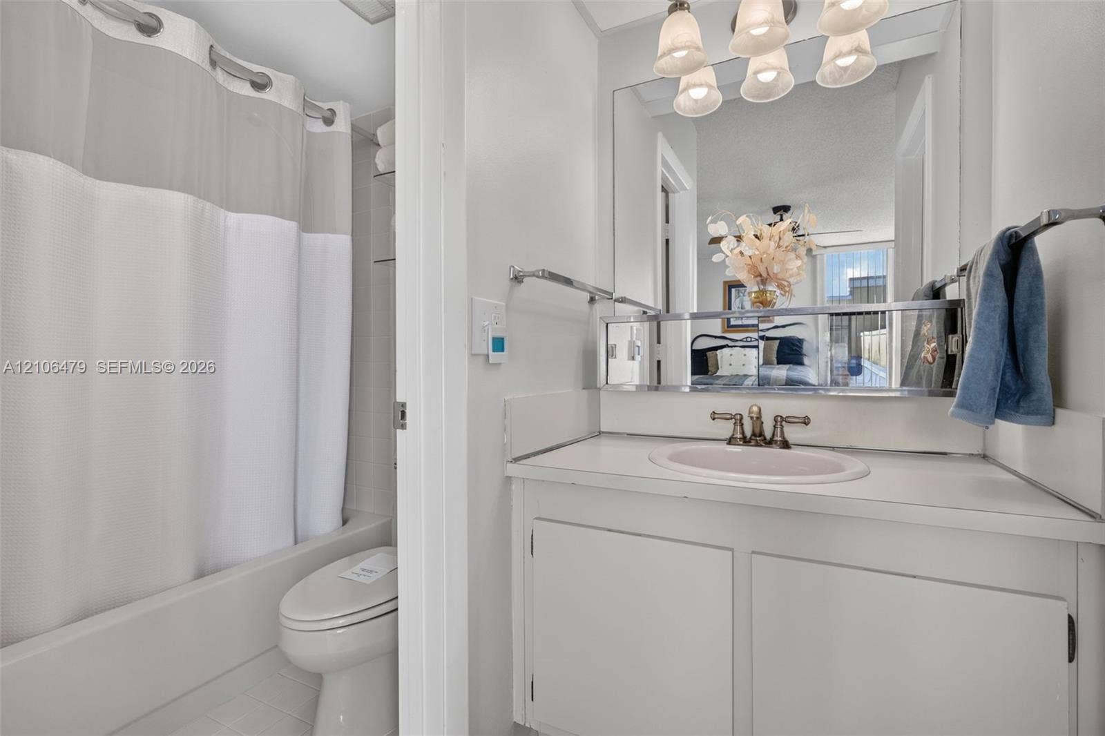 2800 SW 87th Avenue, #1113, Davie, FL 33328 Bathroom featuring a white vanity with integrated sink, metallic widespread faucet, expansive wall-mounted mirror, overhead multi-light fixture, and a combination tub and shower