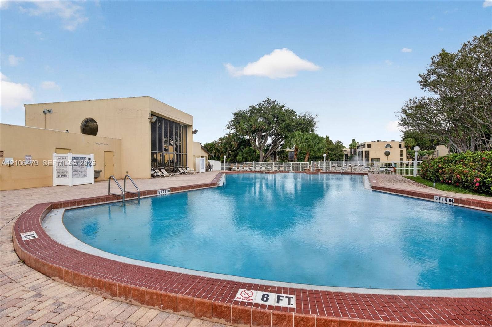2800 SW 87th Avenue, #1113, Davie, FL 33328 In-ground swimming pool featuring a brick-tiled coping, metal pool ladders, and stone-paver decking