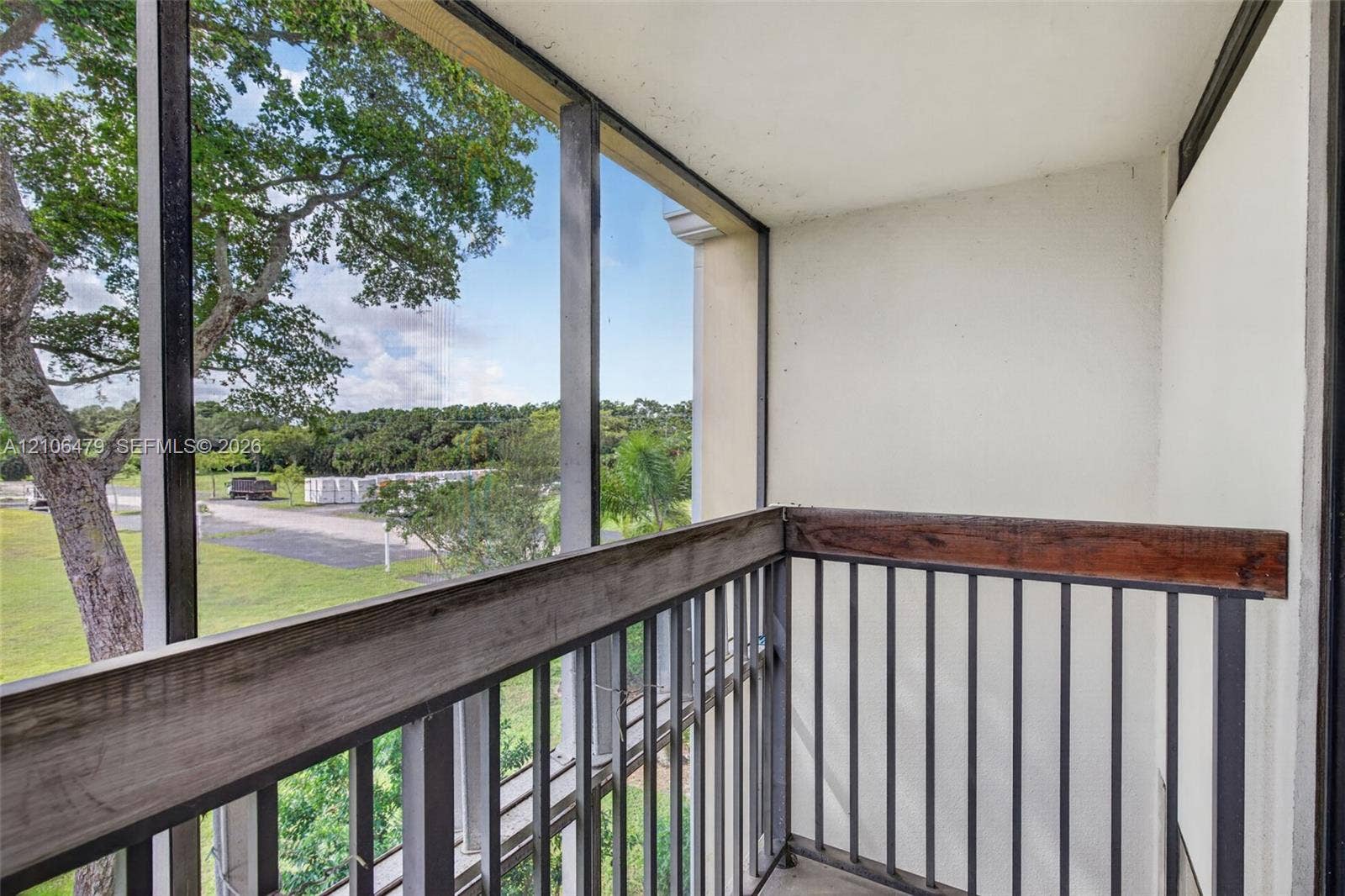 2800 SW 87th Avenue, #1113, Davie, FL 33328 Screened balcony featuring a metal railing with a wood-finish top rail