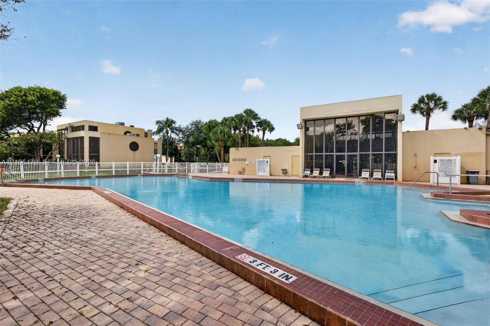2800 SW 87th Avenue, #1113, Davie, FL 33328 Swimming pool featuring a concrete deck, tile coping, integrated steps, and a perimeter safety fence