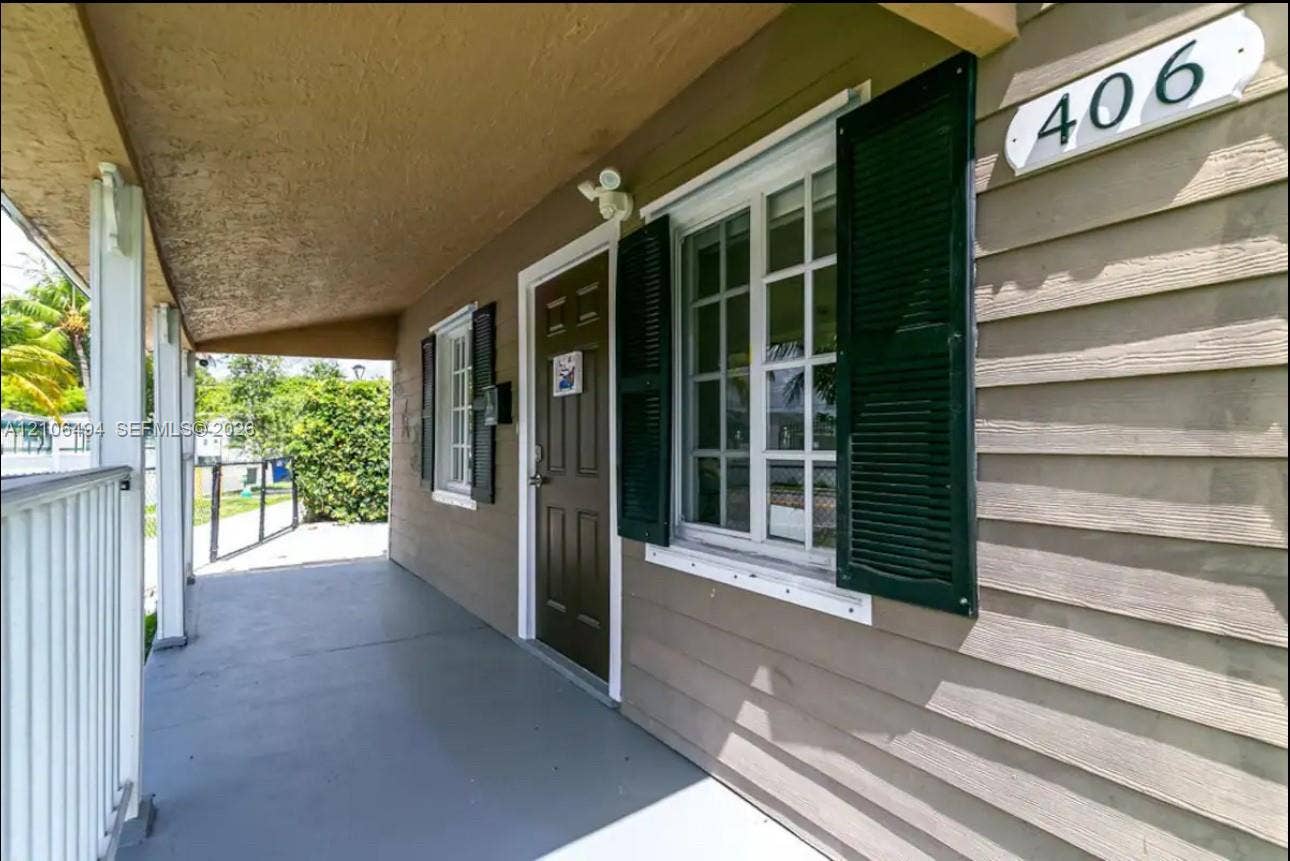 Covered porch featuring lap siding, multi-pane windows with decorative shutters, and a metal railing