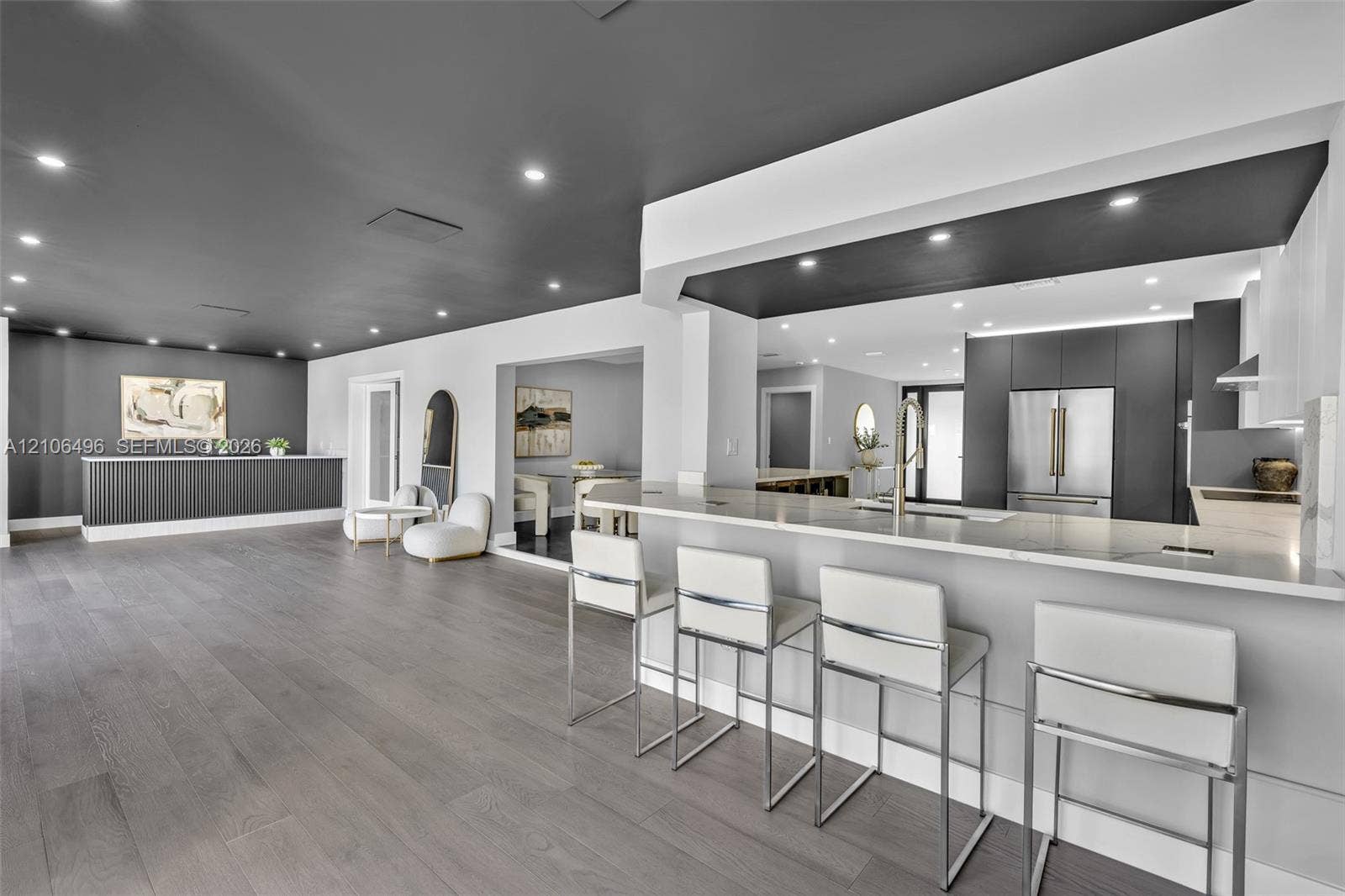 Open concept kitchen featuring a breakfast bar with stone-finish countertops, flat-panel cabinetry, recessed lighting, and wood-finish flooring