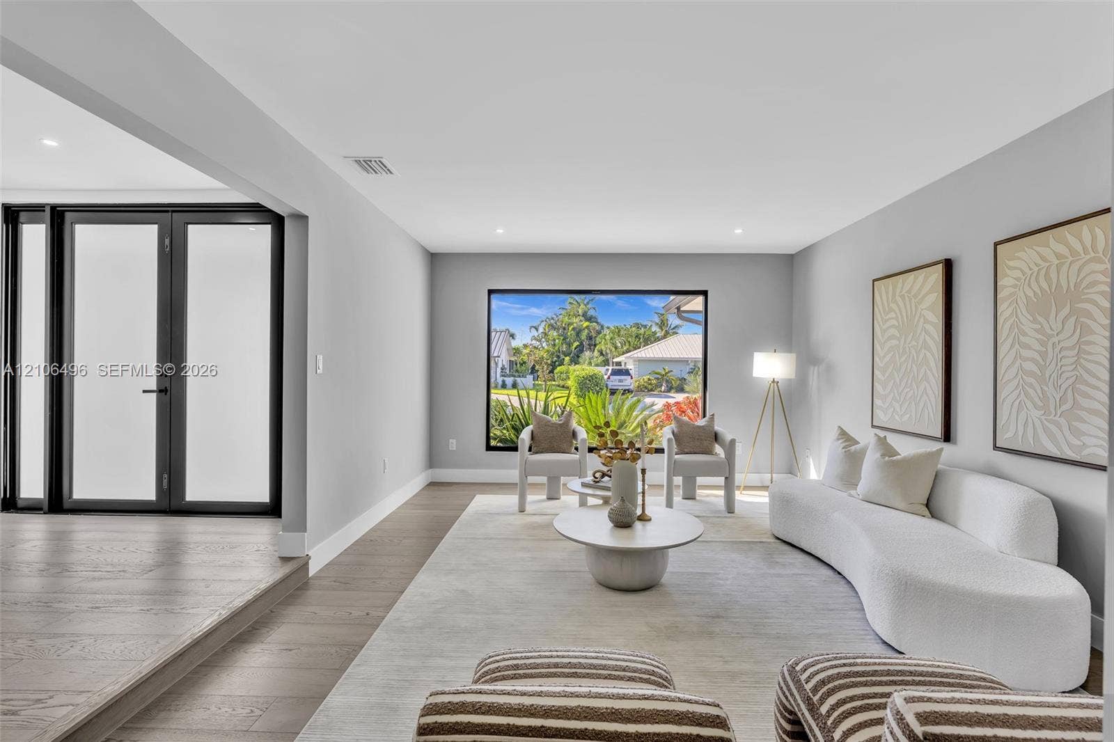 Living area featuring wood-finish flooring, recessed lighting, and large picture window with exterior scenery
