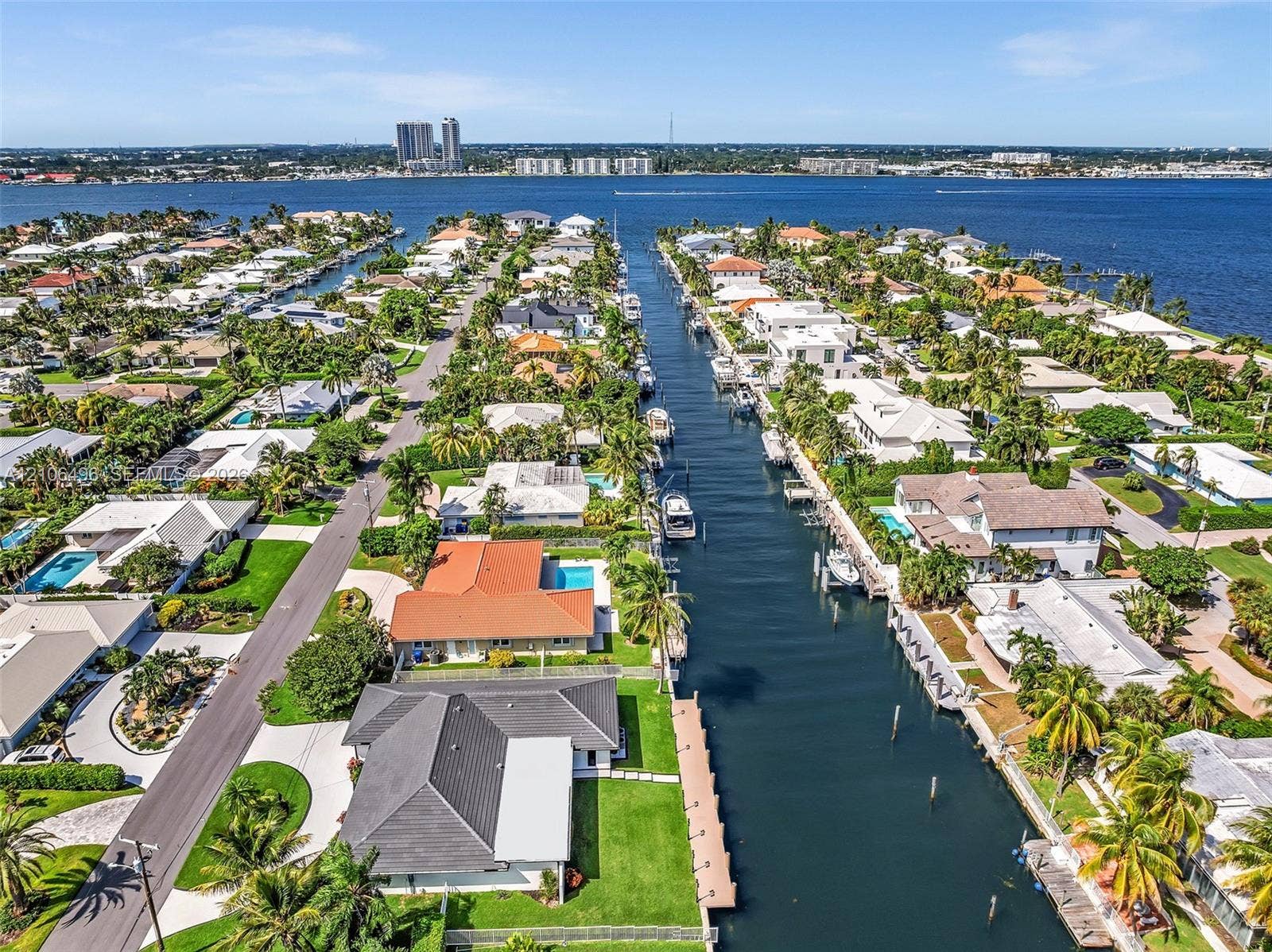 Waterfront canal location featuring direct deep-water access, fixed dock infrastructure, and a landscaped backyard