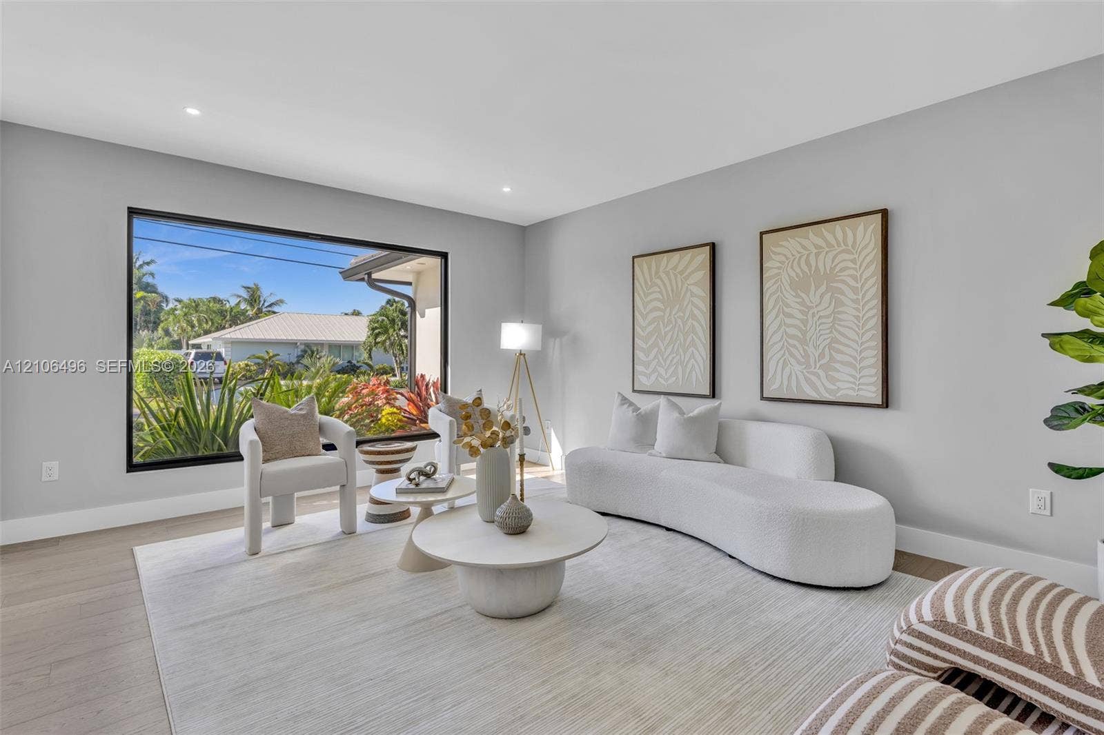 Living space featuring large-format black-frame windows, neutral wall tones, and recessed lighting