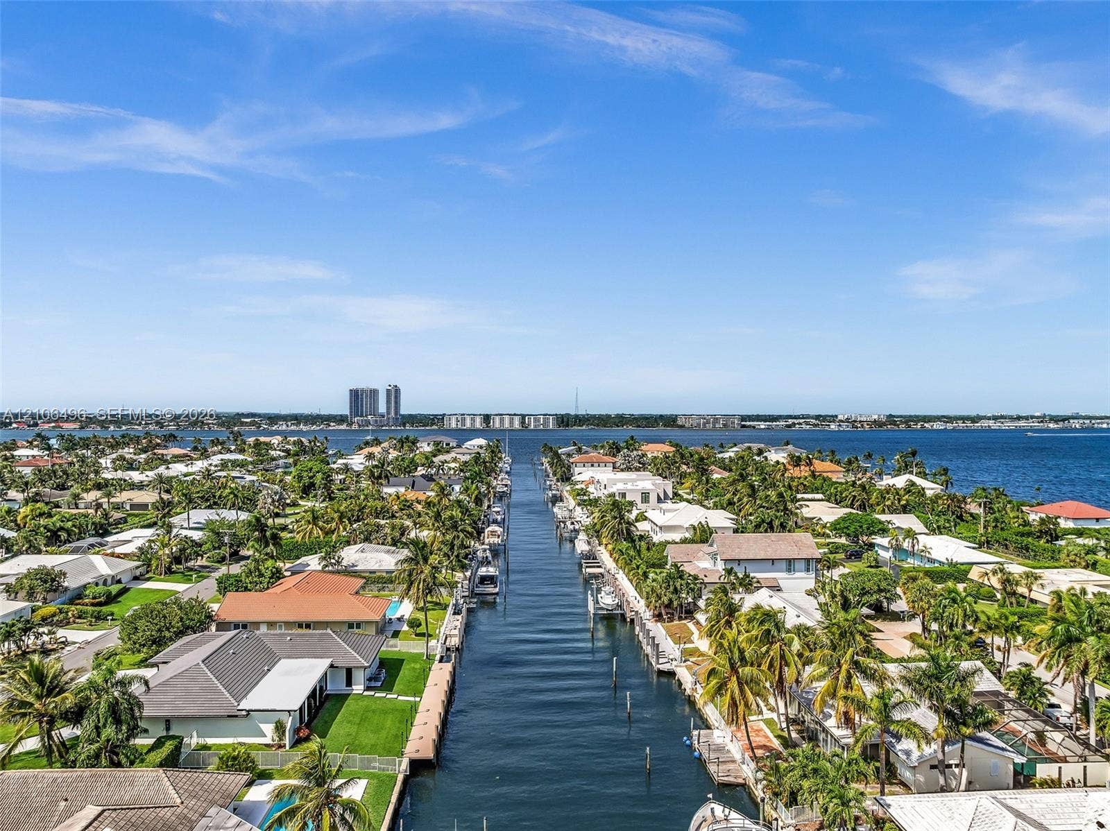 Aerial perspective of waterfront properties featuring direct canal access, private docks, and tropical landscaping