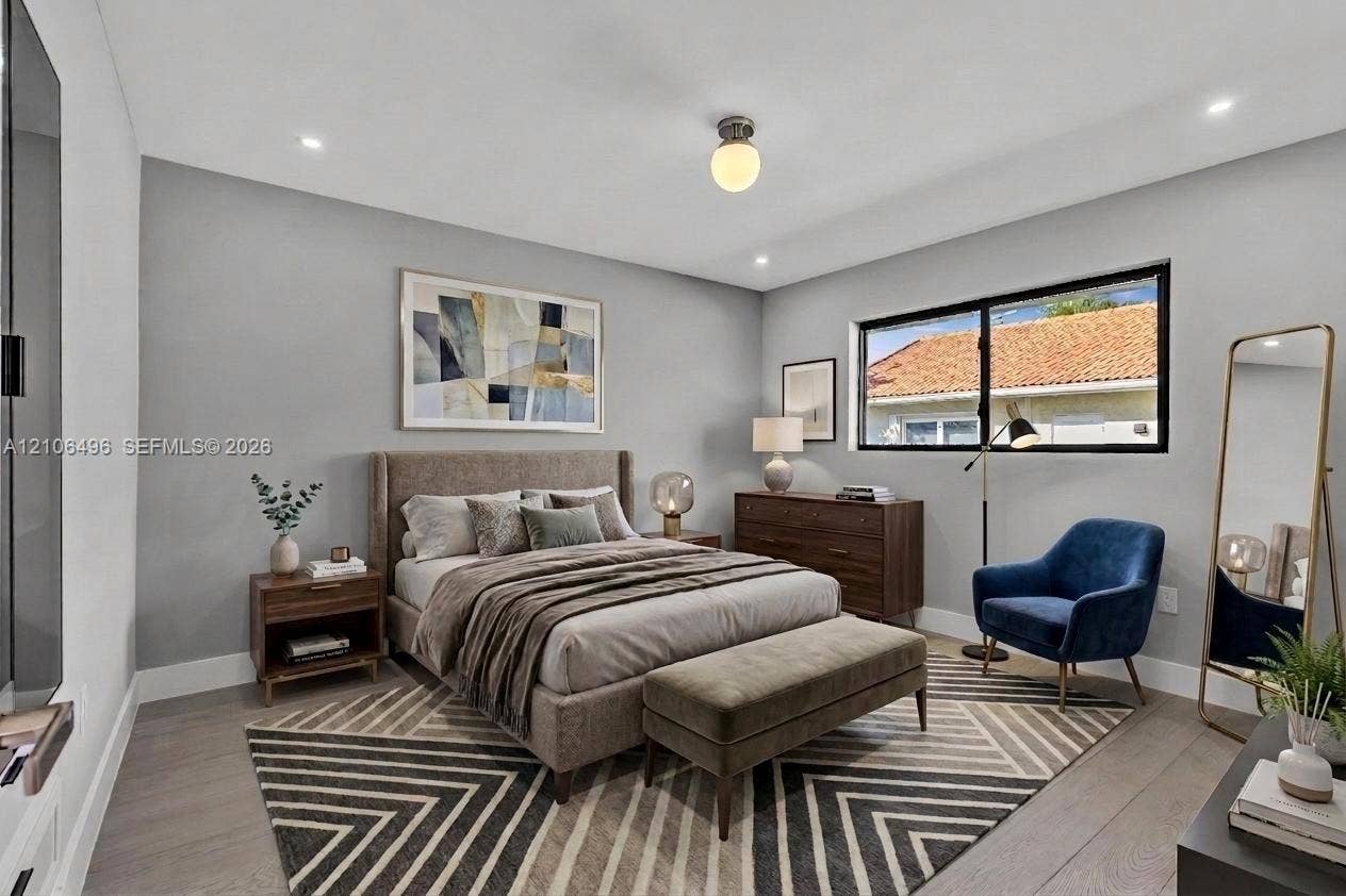 Neutral-toned bedroom featuring wood-finish flooring, recessed lighting, and a single-globe ceiling fixture